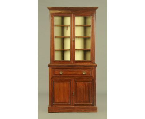 A Victorian mahogany bookcase, with detachable moulded cornice above a pair of glazed doors enclosing adjustable shelves, the