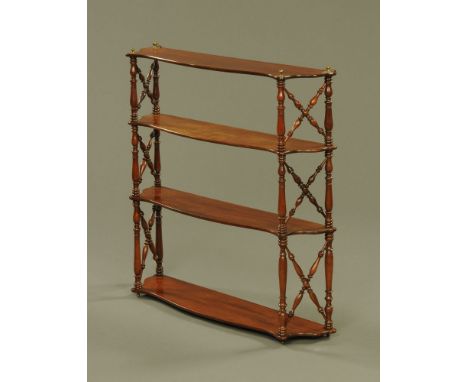 A 19th century mahogany serpentine fronted four tier open shelf unit.  Height 71 cm, width 73 cm, depth 16.5 cm.