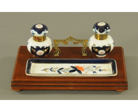 A 19th century continental mahogany and brass mounted ink stand, fitted with a pair of porcelain spherical inkwells and match