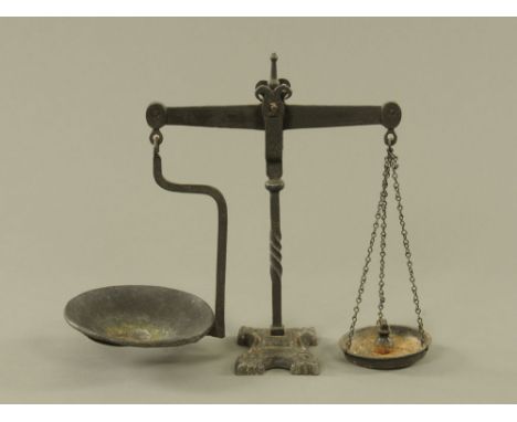 A set of Victorian cast iron balance scales on cast base, with loose pan and single weight. 43 cm high. 