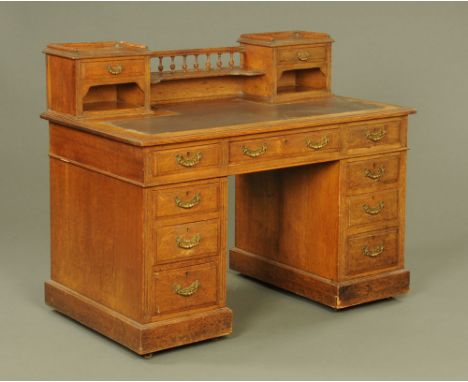 An Edwardian oak pedestal desk by Maple & Co, the superstructure fitted with two drawers and spindle turned back.  Height 100