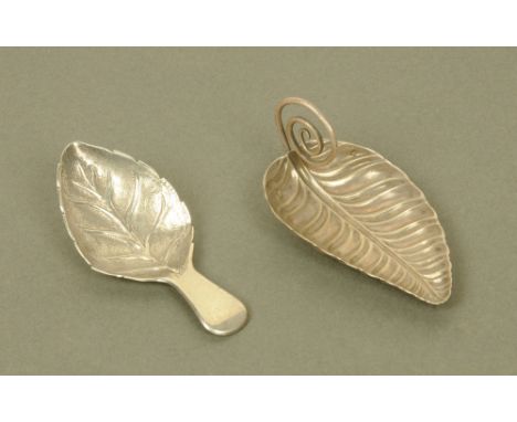 An early 19th century continental (possibly French) white metal leaf form caddy spoon, with vertical scrolled terminal, toget