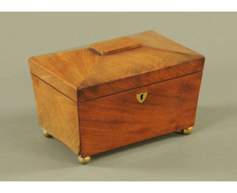 A Victorian mahogany sarcophagus shaped tea caddy, fitted with lidded compartments, on gilt metal ball feet, 17 cm x 22 cm x 