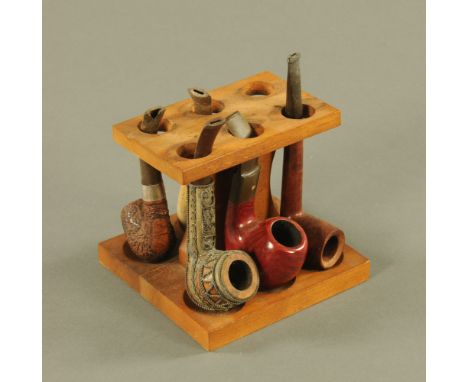 A Fairfax teak six division pipe rack, containing 5 pipes including a Stanwell 42 Royal Rouge pipe.