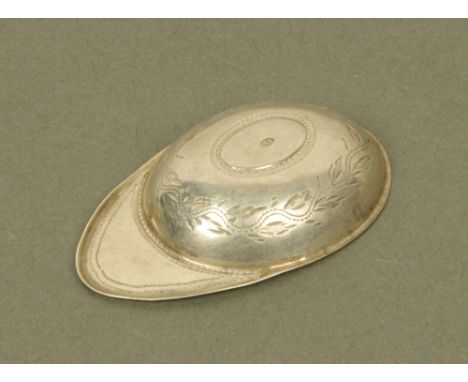An 18th century white metal jockey cap caddy spoon, by Samuel Pemberton, delicately engraved with leaf scrolls (makers mark b