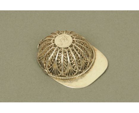 An early 19th century filigree white metal jockey cap caddy spoon, with makers mark internally "TI"  (see illustration). COND