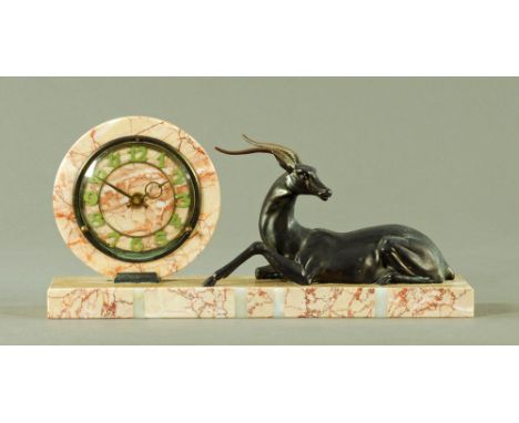 An Art Deco variegated marble circular mantle clock, on rectangular plinth with spelter ibex.  Length 45 cm, height 22 cm, de