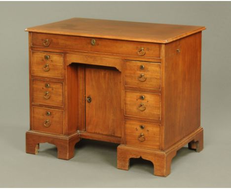 A George III gentleman's kneehole dressing chest, with lifting top enclosing fitted interior with mirror, on bracket feet.  H