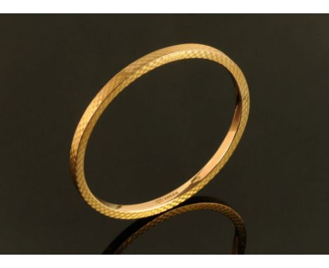 A 9 ct gold engine turned bangle, hollow, large, internal diameter 76 mm, 10.4 grams.