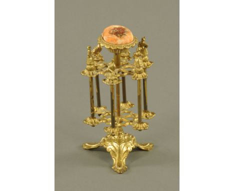 A Victorian ormolu 6 spool reel holder the pin cushion top with leaf moulding, the holders with figural and bird finials on s