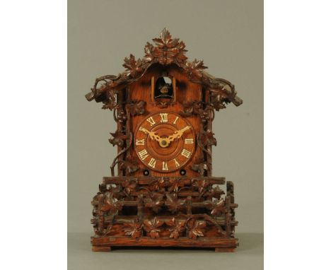 A 19th century Black Forest Cuckoo bracket clock, with two train fusee type movement, with carved case and compete with key a