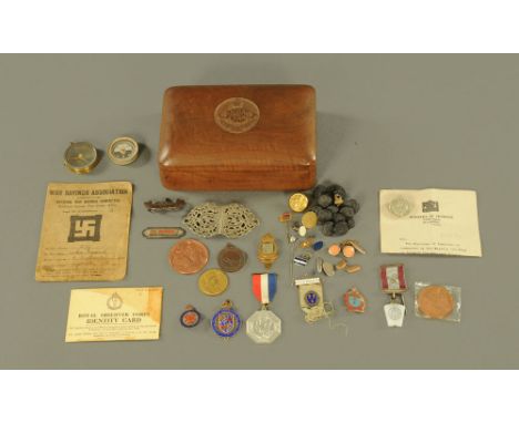 A Dorset Regiment carved wooden box, containing a quantity of medals, buttons, compass etc.