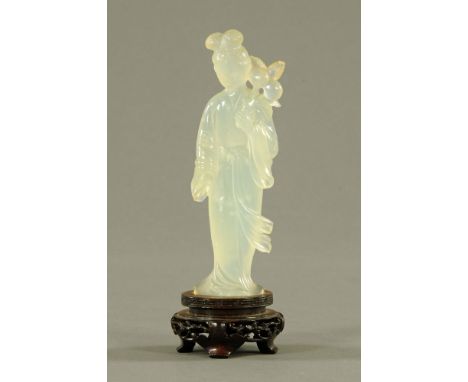 A Chinese carved jade figure of a standing woman, on rosewood stand, 17 cm high. CONDITION REPORT: Slight chipping in places