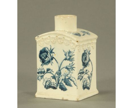An 18th century creamware pottery tea caddy, with curved top and moulded in relief with leaves, decorated in blue with dog ro