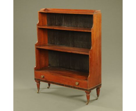 An early Victorian figured mahogany waterfall bookcase, with low gallery fitted single drawer on turned legs and castors.  16
