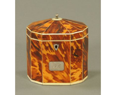 A George III blond tortoiseshell decagonal tea caddy, the angled top with white metal finial and inlaid with ivory stringing,