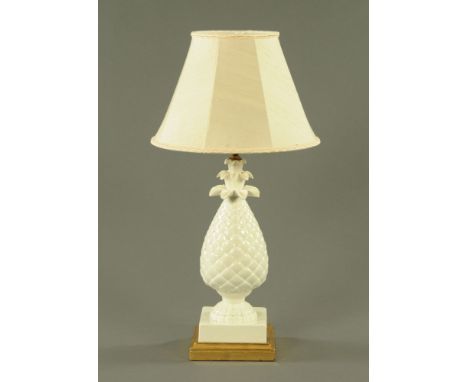 A white glazed porcelain pineapple shaped electric table lamp, on gilt base and with shade.  10 cm high.  CONDITION REPORT: T