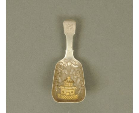 A George III silver fiddle pattern caddy spoon, by George Knight, the bowl with gilded Eastern temple surrounded by embossed 