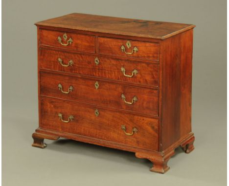 A 19th century oak chest of drawers, with moulded edge above two short and three long graduated drawers with brass drop handl