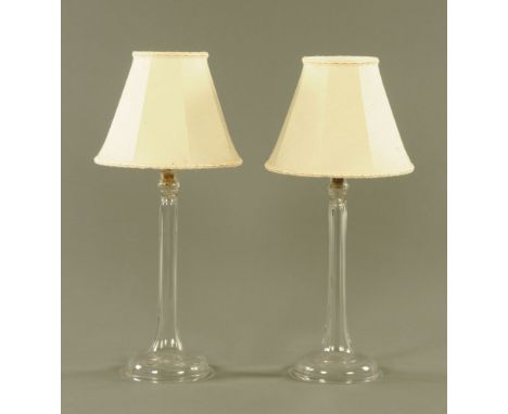 A pair of moulded clear glass electric table lamp bases, with shades.  69 cm high. 