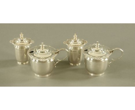 A pair of silver mustard pots, each with blue glass liner, Sheffield 1924, together with a pair of matching pepperettes of th