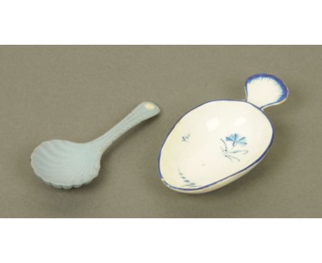 An early 19th century blue and white porcelain oval caddy spoon, with scalloped terminal, the bowl decorated with floral spra