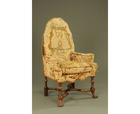 A Queen Anne style tapestry armchair, with loose cushion and rounded outswept arms and raised on gilt and red painted lobed a