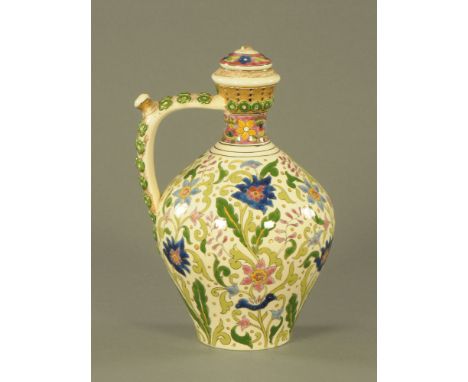 An early 20th century Hungarian pottery puzzle jug, of Zsolnay Pecs design, decorated throughout in colours with scrolled lea