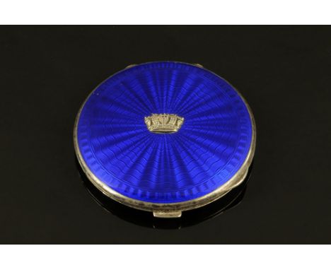 An Art Deco silver and blue enamel RN powder compact, engine turned.  Diameter 7.5 cm. CONDITION REPORT: The compact is hallm