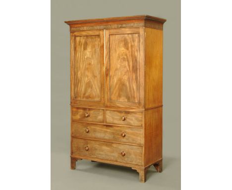A 19th century figured mahogany press cupboard, with moulded cornice above two panelled doors opening to internal slides, wit