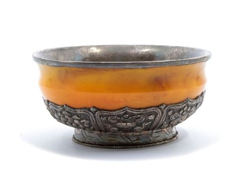 A Bhutan silver-mounted amber bowl, the base of the bowl with lappets decorated in repoussé with the Eight Buddhist Emblems (