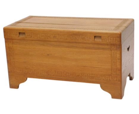 A carved Eastern camphor wood chest, decorated with Greek key design, on bracket feet, 89cm wide.