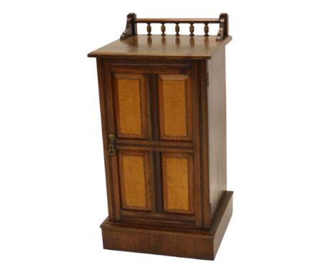 A late 19thC walnut and maple pot cupboard, the top with spindle turned raised gallery and a moulded edge, above a door with 