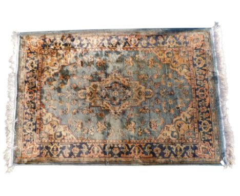 A modern cotton machine woven rug, in Persian style, with cream medallion, on a Navy blue ground, one wide and two narrow bor