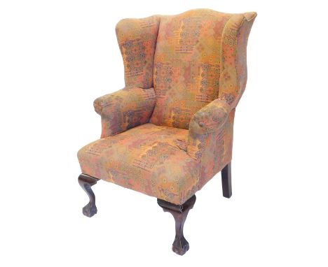 A mahogany wingback chair, in mid 18thC style, upholstered in multicoloured Persian carpet designed fabric, on cabriole legs 
