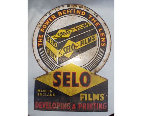 A 'SELO FILMS'  PHOTOGRAPHY ENAMEL ADVERTISING SIGN in the form of a lens; 'THE POWER BEHIND THE LENS' 43 X 58cm  (rust, chip