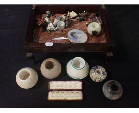 A TABLE DISPLAY CASE containing a miniature portrait of a young man and sundries