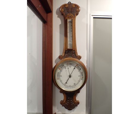 A VICTORIAN GOLDEN OAK-CASED ANEROID BAROMETER with white dial and thermometer 98cm long (top piece of thermometer frame miss