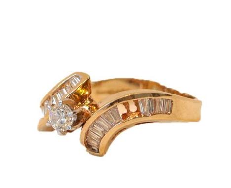 A 9 carat gold diamond solitaire ring, the round brilliant cut diamond in a white claw setting, to tapered baguette cut diamo