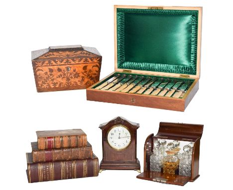 An Edwardian inlaid mahogany miniature three bottle tantalus, a marquetry inlaid tea caddy, an early 20th century canteen of 