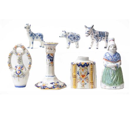 A quantity of Continental faience, mainly Rouen, including octagonal candlestick, inkwells, figural bell, tea canister and co