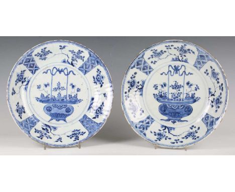 A pair of Chinese blue and white export porcelain circular dishes, Kangxi period, each painted with a central flower basket w