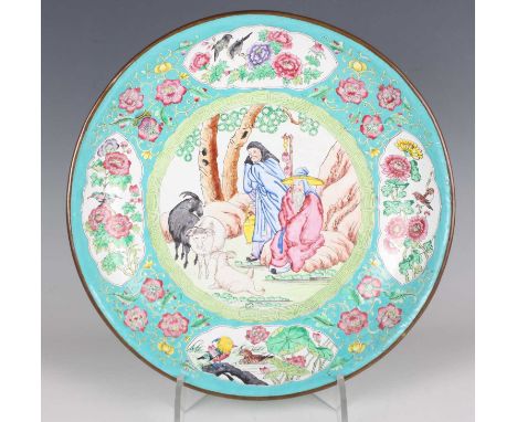 A Chinese Canton enamel circular dish, late 20th century, painted with a central scene of three goats and two herdsmen, withi