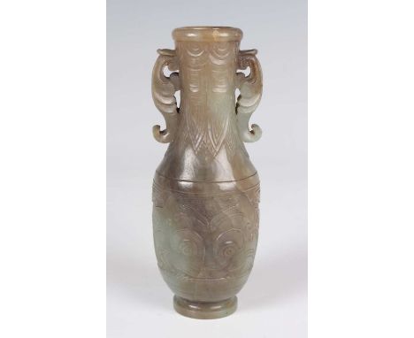 A Chinese archaistic jade vase, Qing dynasty, the ovoid body and flared narrow neck carved in low relief with bands of taotie