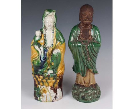 A Chinese sancai glazed porcelain figure of Guanyin, early 20th century, modelled seated with acolyte on a lotus moulded base