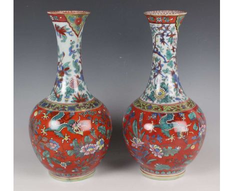 A pair of Chinese 'clobbered' blue and white porcelain bottle vases, each squat ovoid body and flared narrow neck painted wit