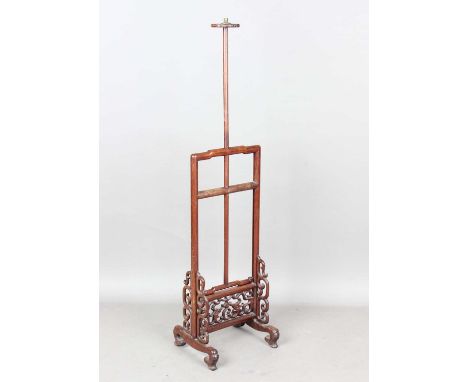 A Chinese hardwood adjustable standard lamp, early 20th century, the open frame with carved and pierced dragon scroll panels,