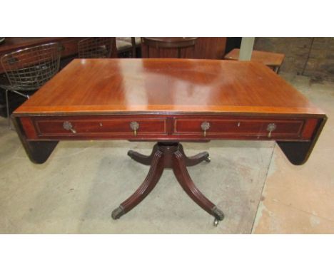 A Georgian mahogany sofa table, with inlaid crossbanded detail, fitted with two real and two dummy drawers, raised on a possi