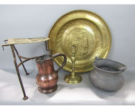A collection of interesting metalware to include a brass charger embossed with a biblical scene, a wrought iron brass trivet,