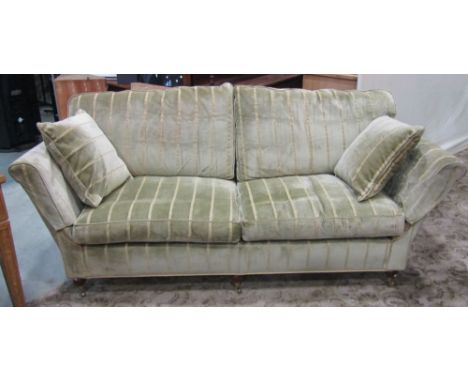 A good quality contemporary three seat sofa, with shaped outline and green ground, striped upholstered finish with loose cush